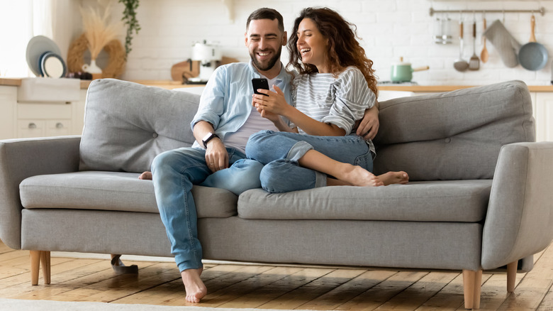 happy couple smiling on a sofa