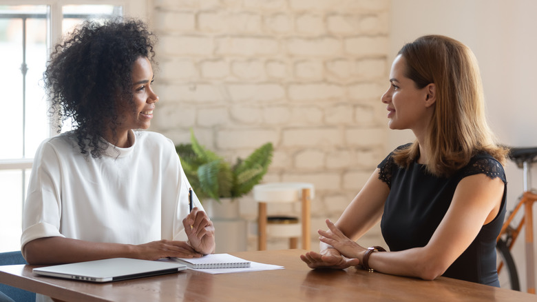 Two females having a conversation at work