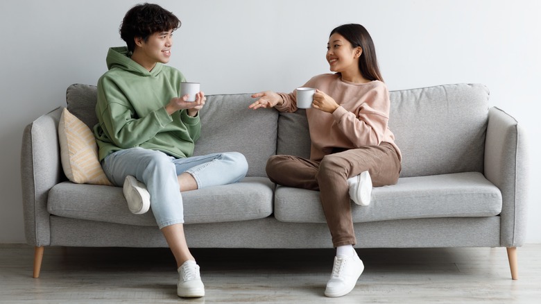 asian couple talking on a couch