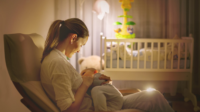 Mother nursing baby in rocker