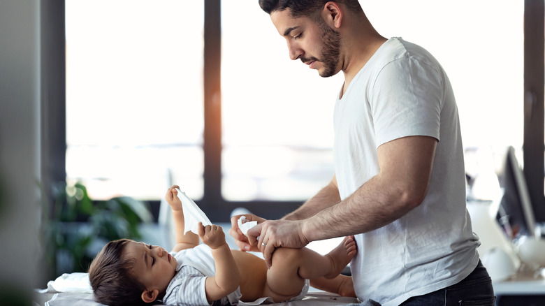 Dad changing baby's diaper