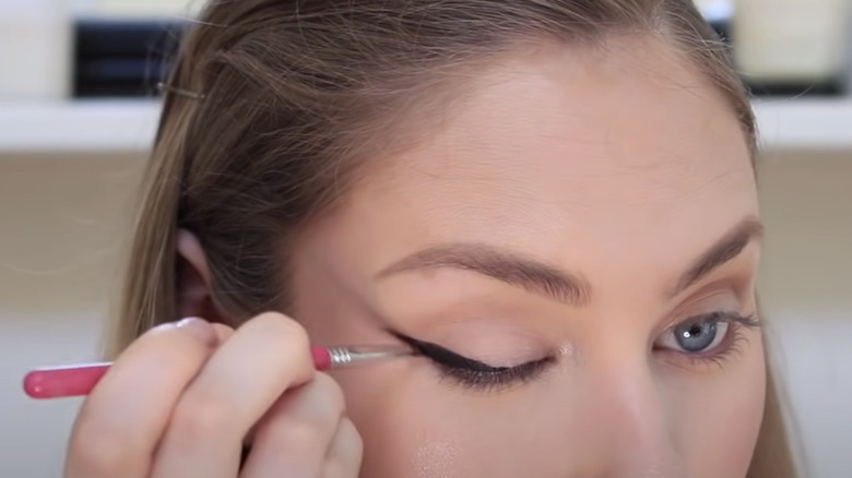 woman applying winged liner