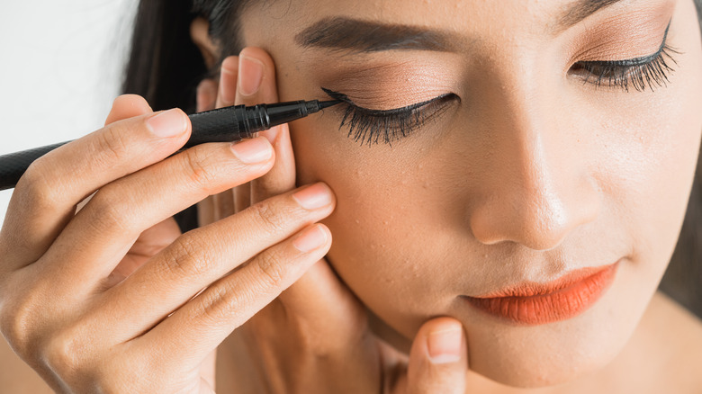 woman applying eyeliner