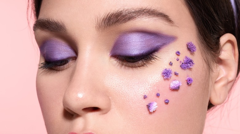 woman with lilac eyeshadow and lilacs on face
