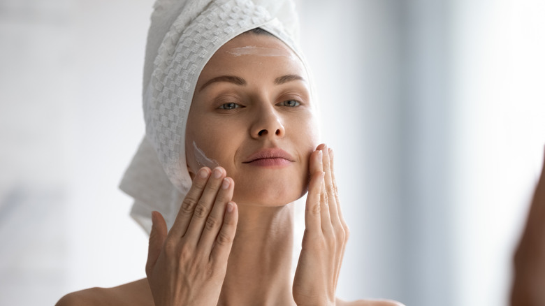 woman applying moisturizer 