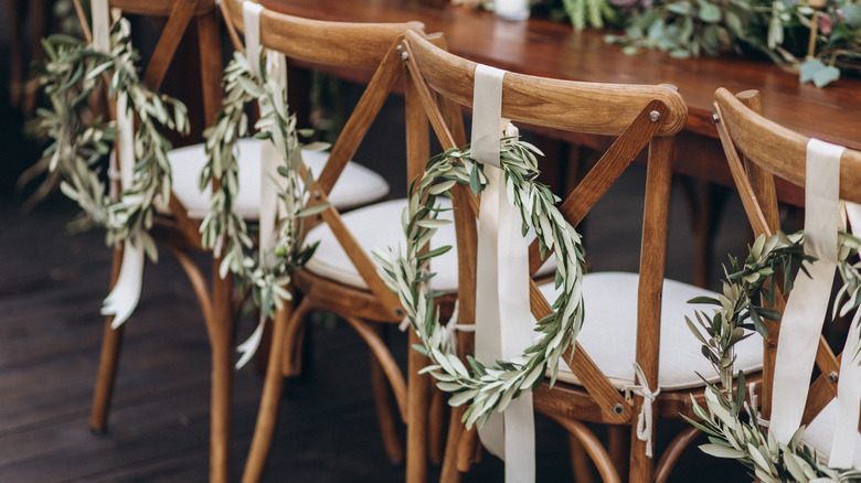 Wedding chairs decorated with green wreaths