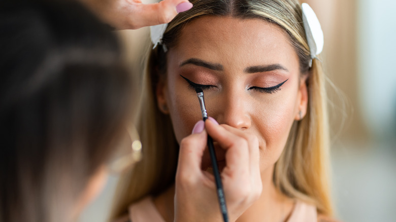 makeup artist doing woman's eyes