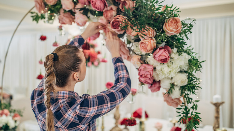 Bride making a flower arch 