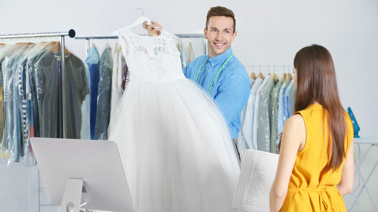 woman at dry cleaners with wedding dress