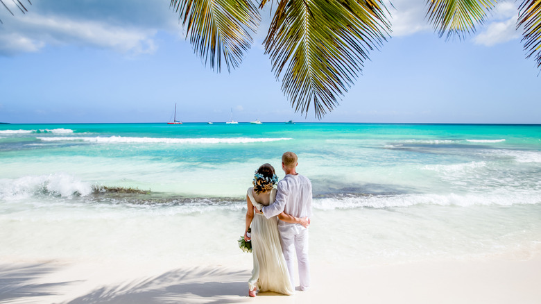 Couple views tropical beach wedding venue