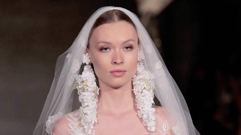 Model wearing veil and long earrings