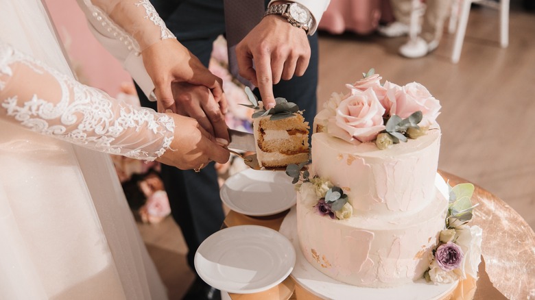 A bride and groom cutting cake