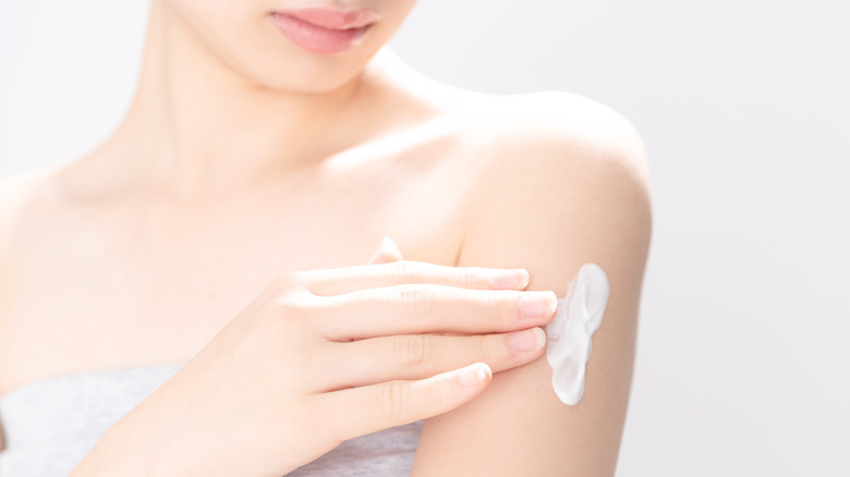 female applying cream or lotion to her arm