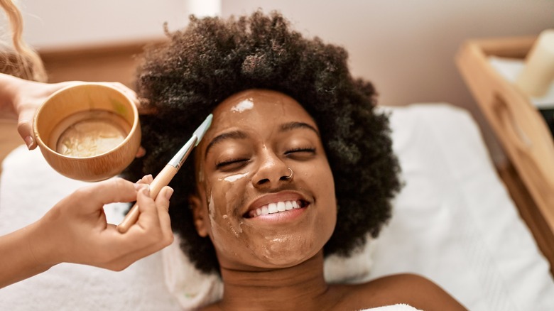 Woman receiving facial treatment at spa