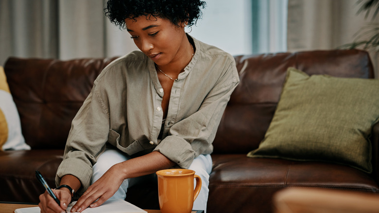 Woman journaling on couch