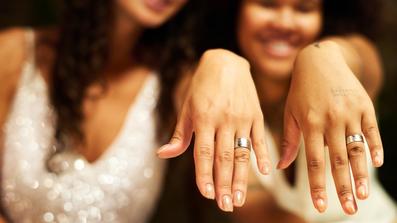 Two brides showing their wedding rings 