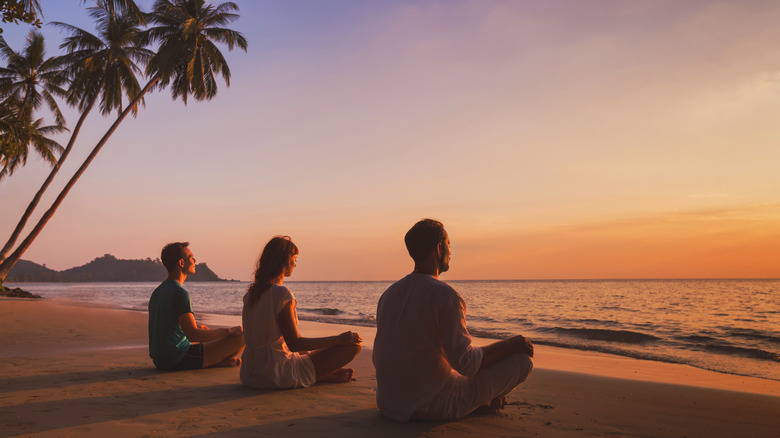 People meditating on beach