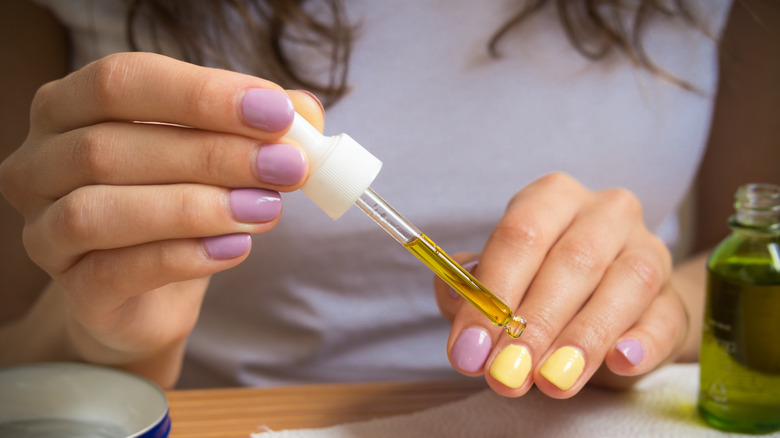 woman applying nail oil