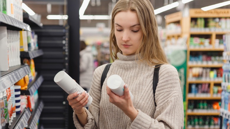 woman comparing hair products in store