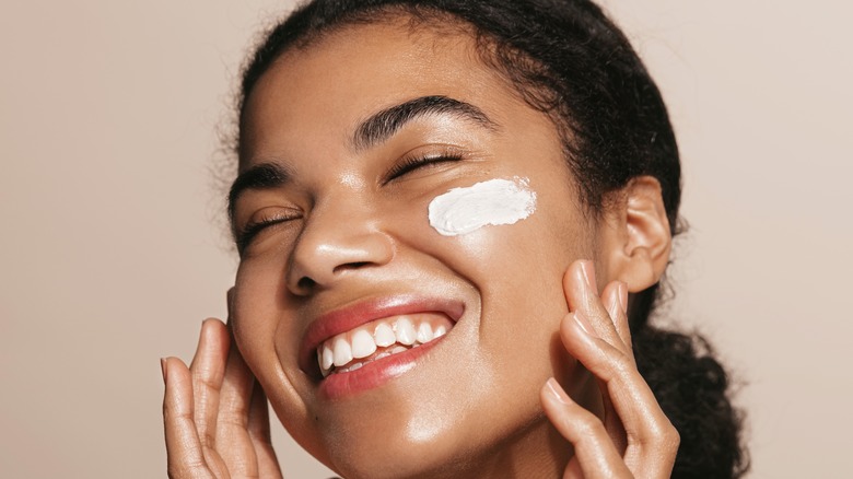 smiling woman with cream on cheek