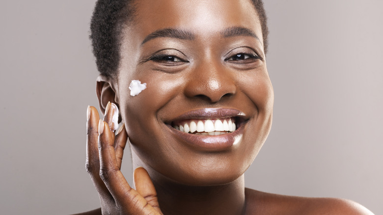smiling woman with cream on cheek