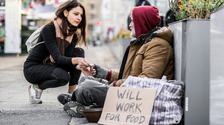 Woman gives homeless man money