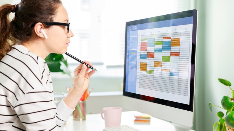 Woman meticulously organizes digital calendar 
