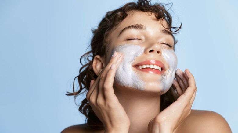 woman applying clay mask