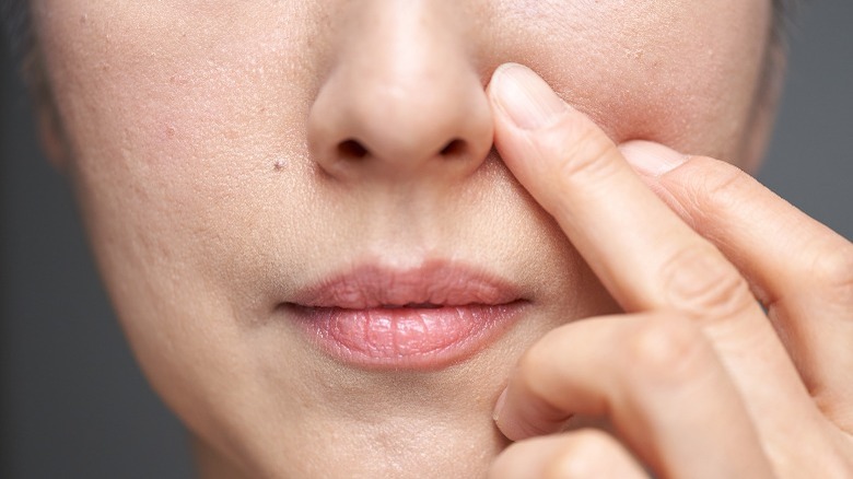 Older woman touching face