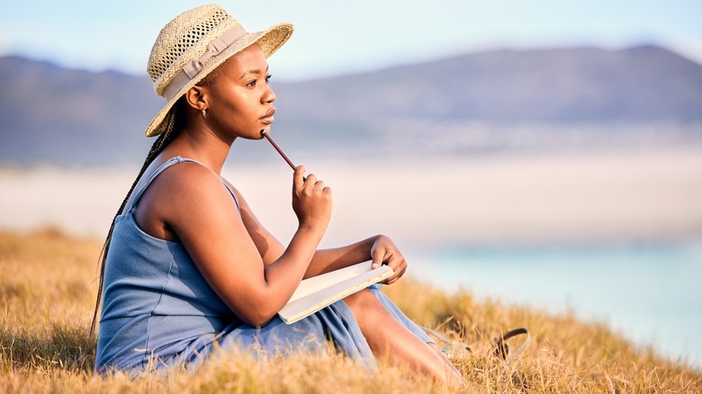 Woman writing in journal outdoors