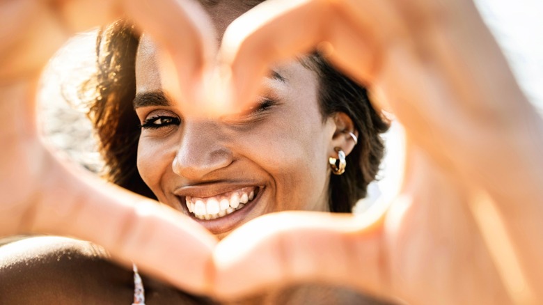 a woman holding up a heart to show self-love