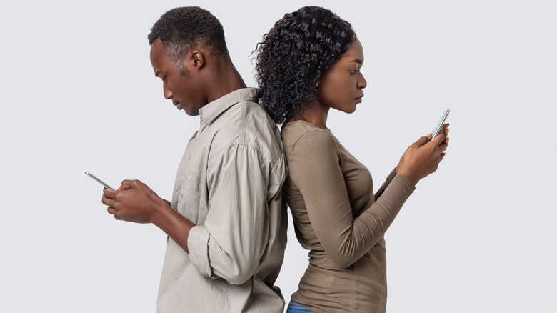 African American couple looking at their phones