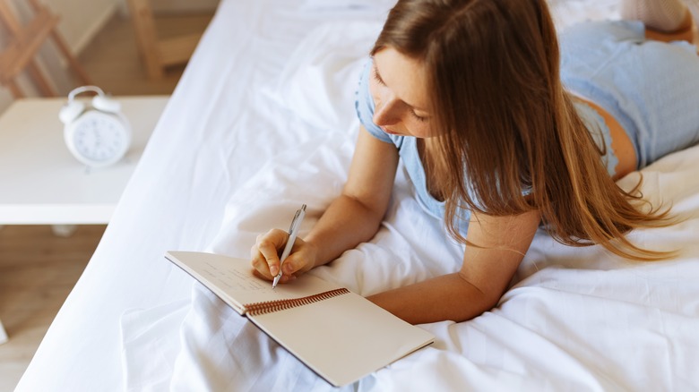 Woman journals in bed