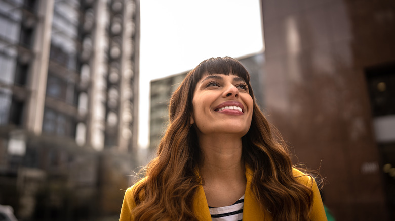 woman outside smiling and looking up