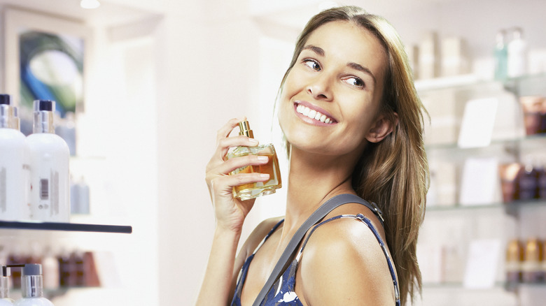 Woman spraying perfume