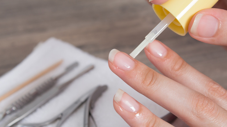 person applying cuticle oil