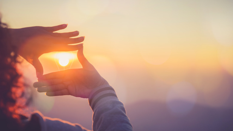 Woman frames sun 