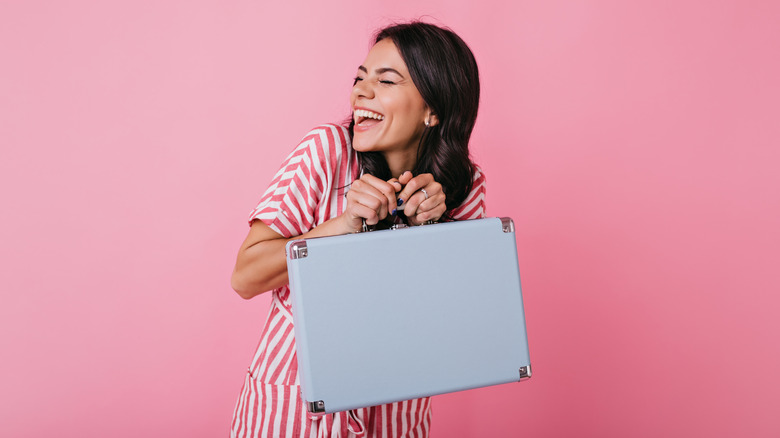 Woman holding a briefcase and laughing