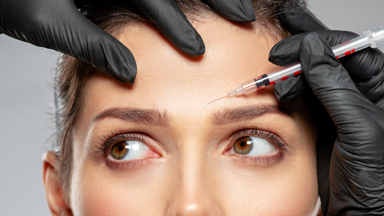 Close up of woman getting Botox injection in forehead