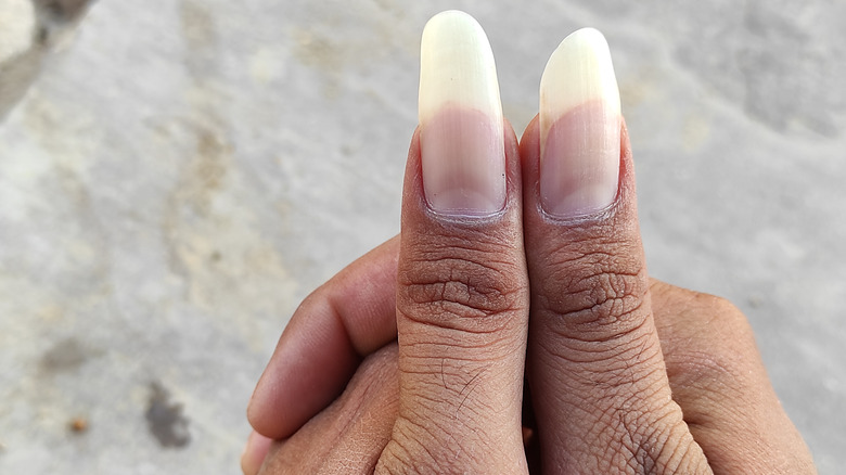 Hand with long thumb nails