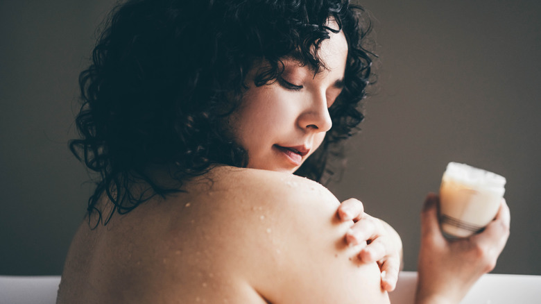 Woman applying body lotion