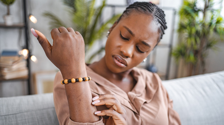 Woman examining dry, irritated skin