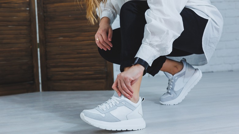 woman putting on sneakers