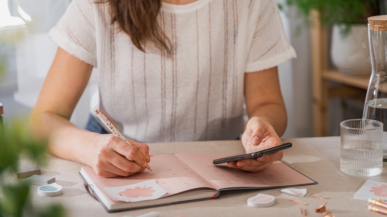 Woman writing dates in a calendar