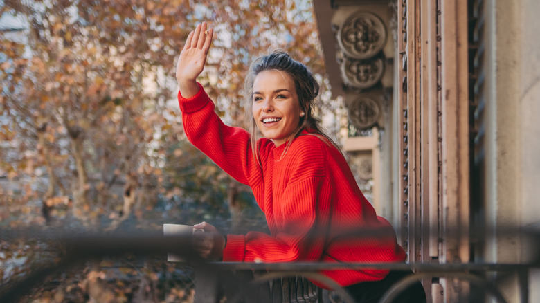 Woman waving from her balcony