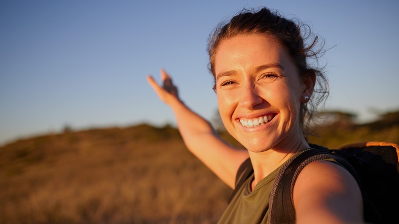 Woman smiling outdoors at sunrise