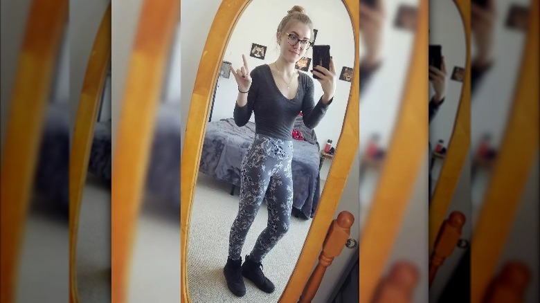 Woman takes mirror selfie in groutfit 