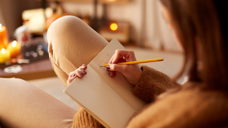 Woman journaling in living room 