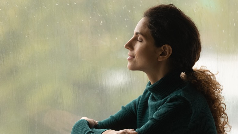 Woman listening to rain indoors