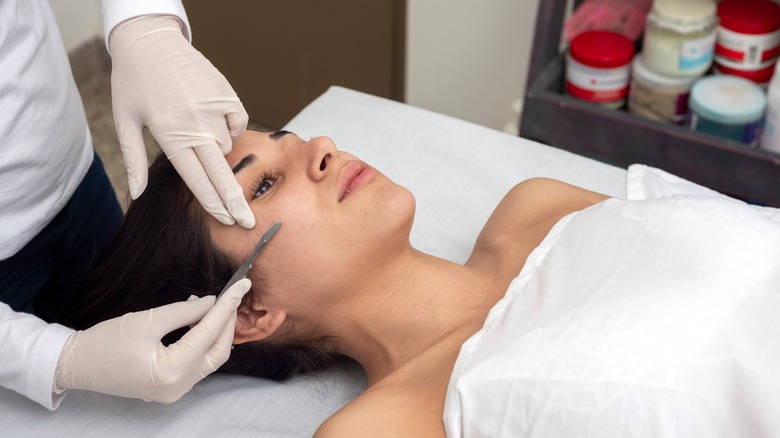 Woman getting dermaplaning treatment